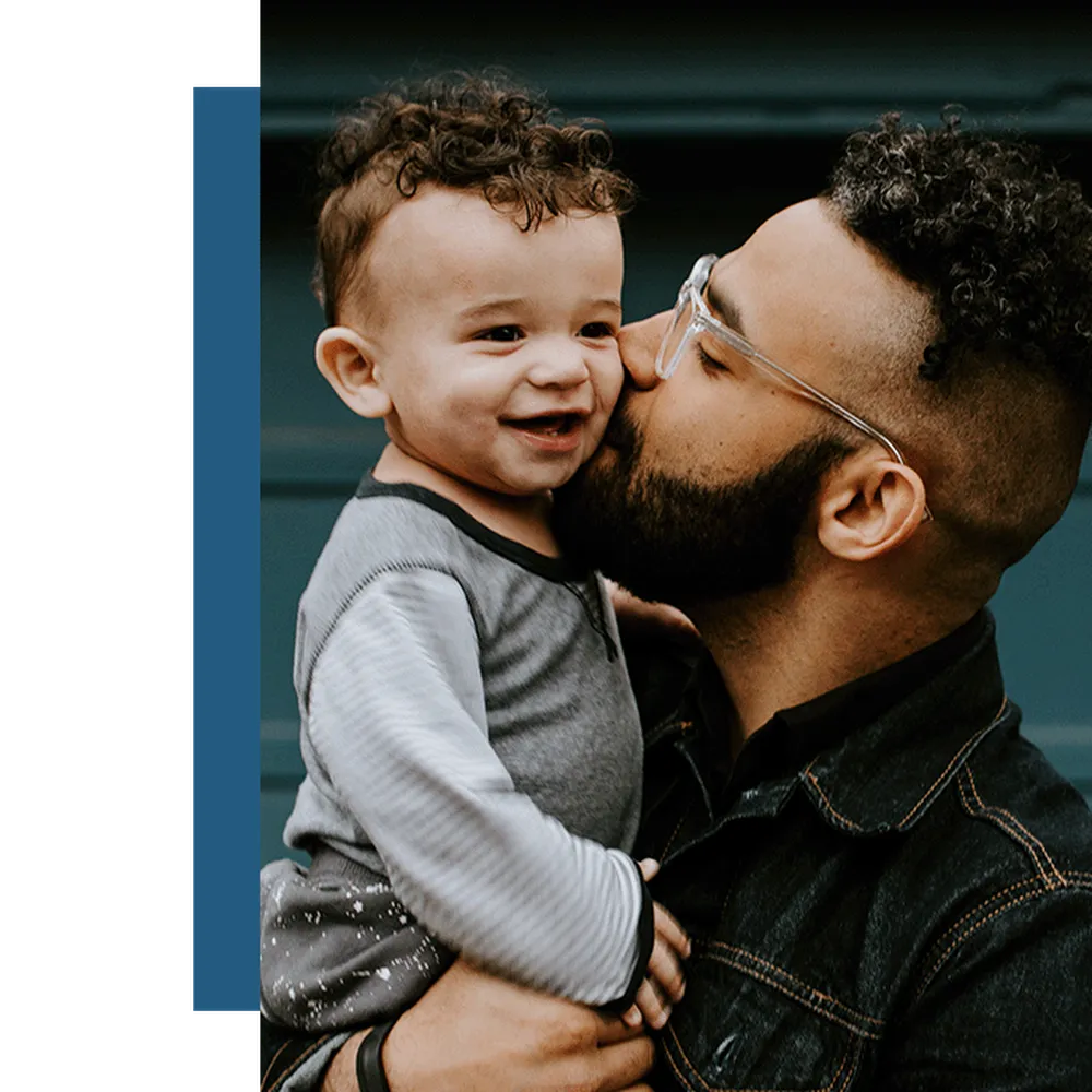 Father kissing his son while holding him