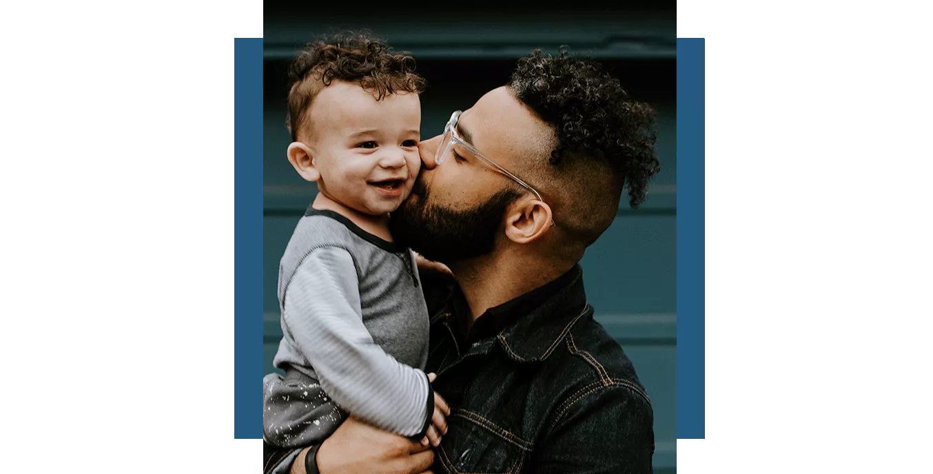 Father kissing his son while holding him