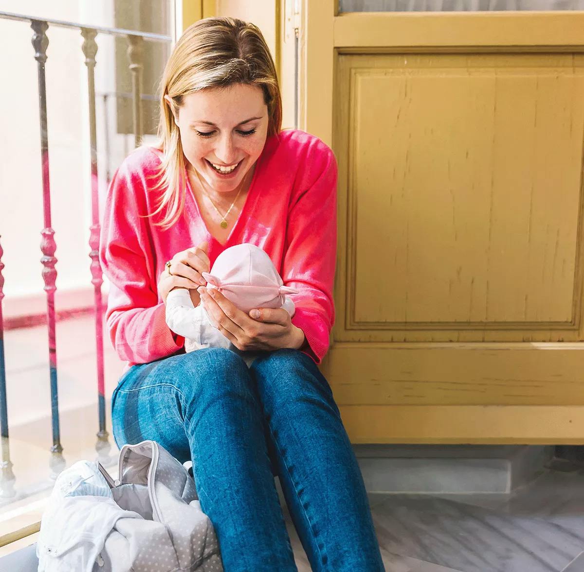 Young woman looking at her baby and smiling