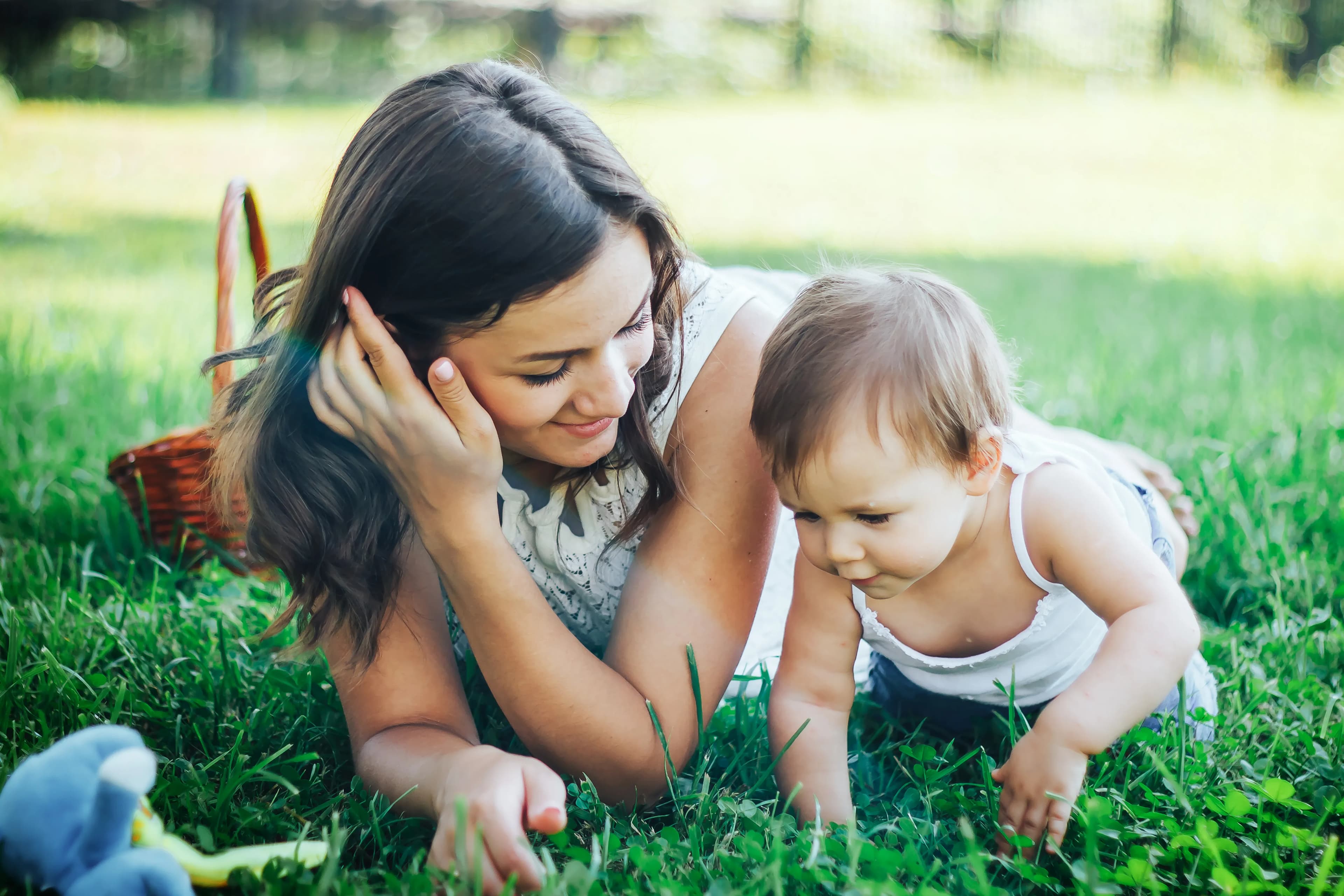 A single mother lay on the grass with her daughter