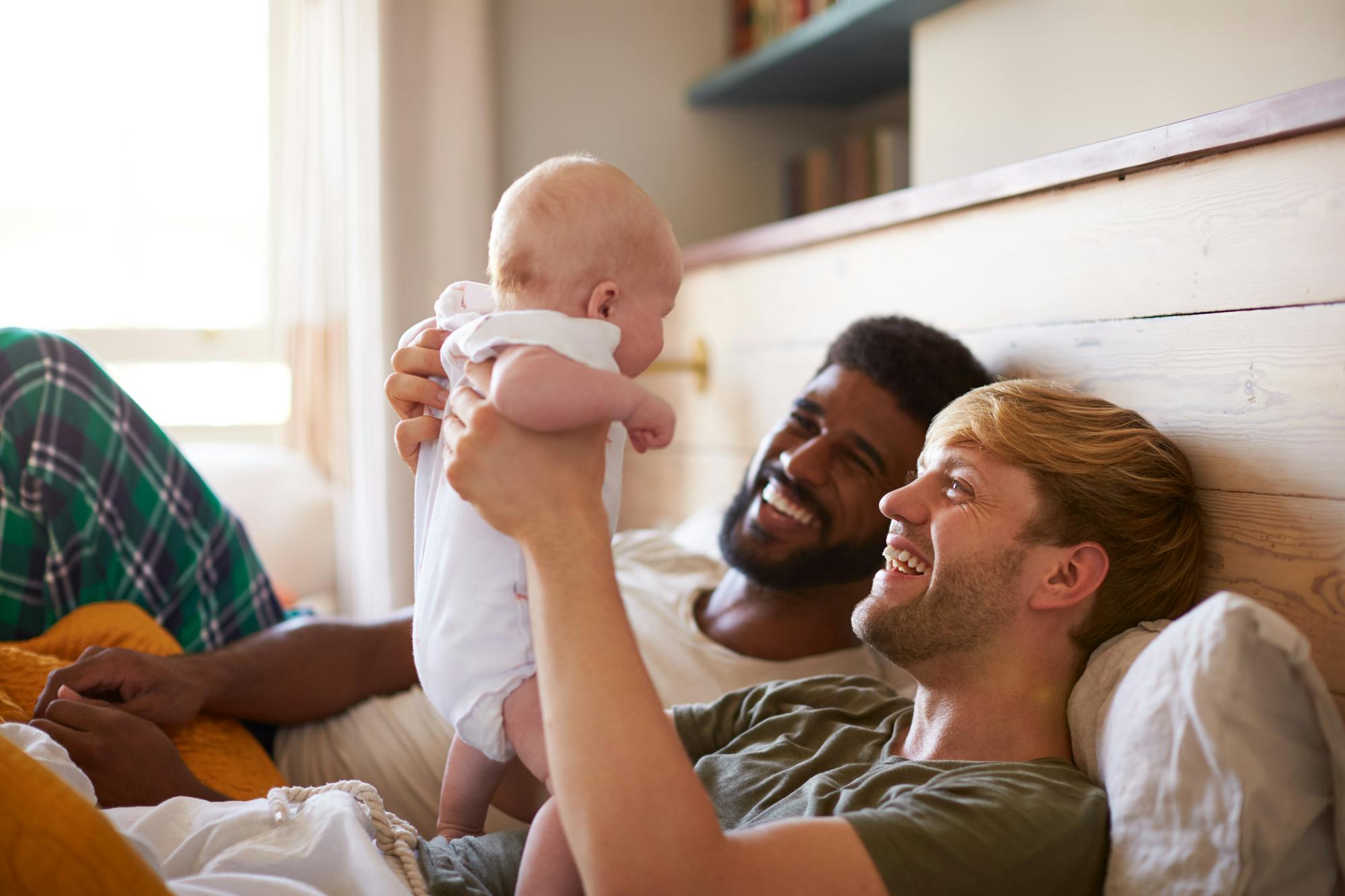 2 dads, holding baby