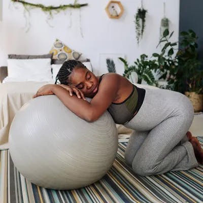 women resting on a yoga ball